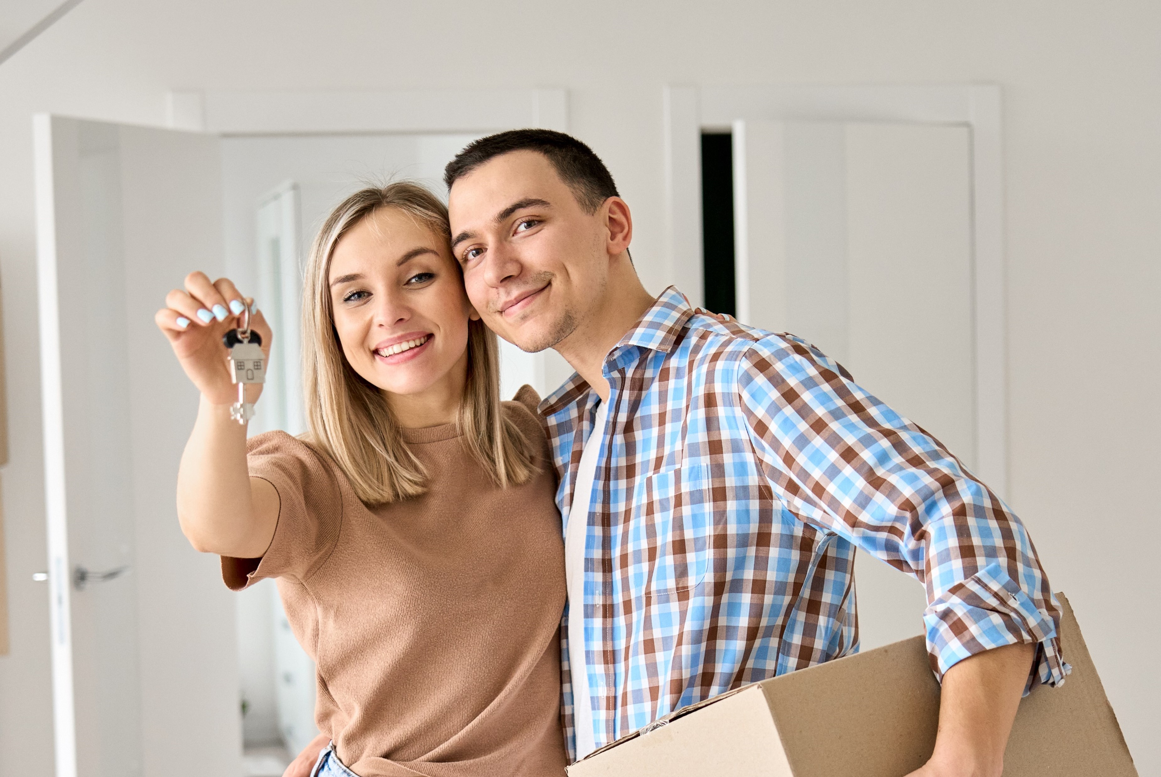 Couple moving into their home and woman holding a key