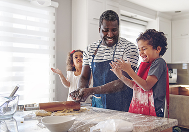 dad and two young kids baking together