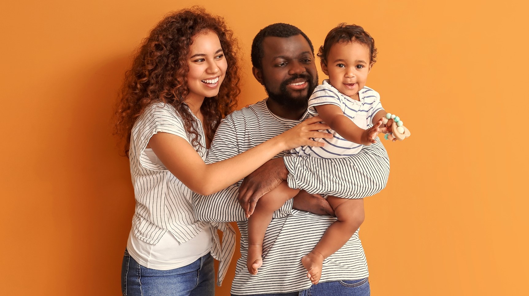Couple with baby wearing black and white stripes