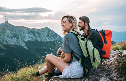 Un jeune couple prenant une pause lors d’une randonnée en montagne