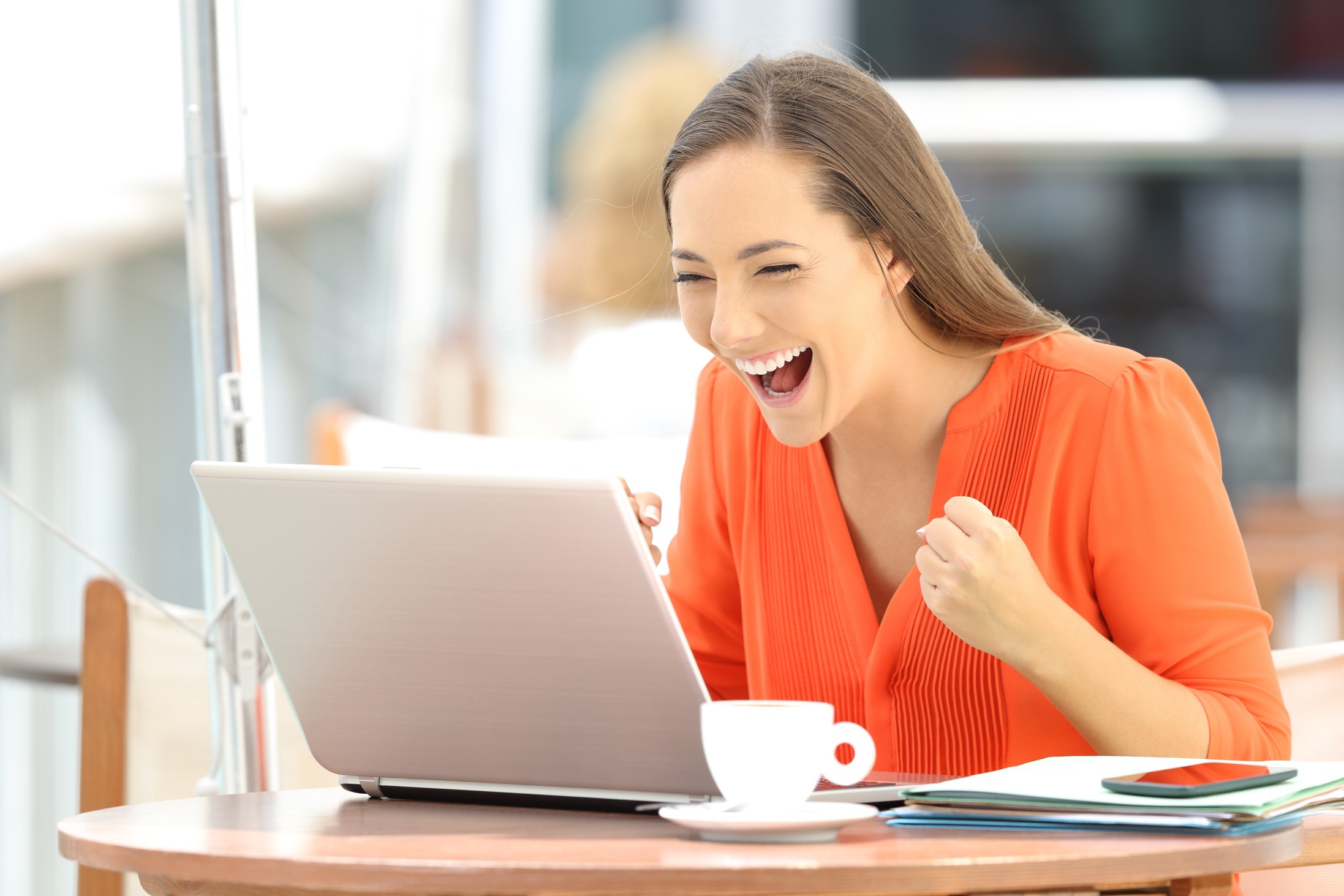 A Woman Laughing While Using A Computer